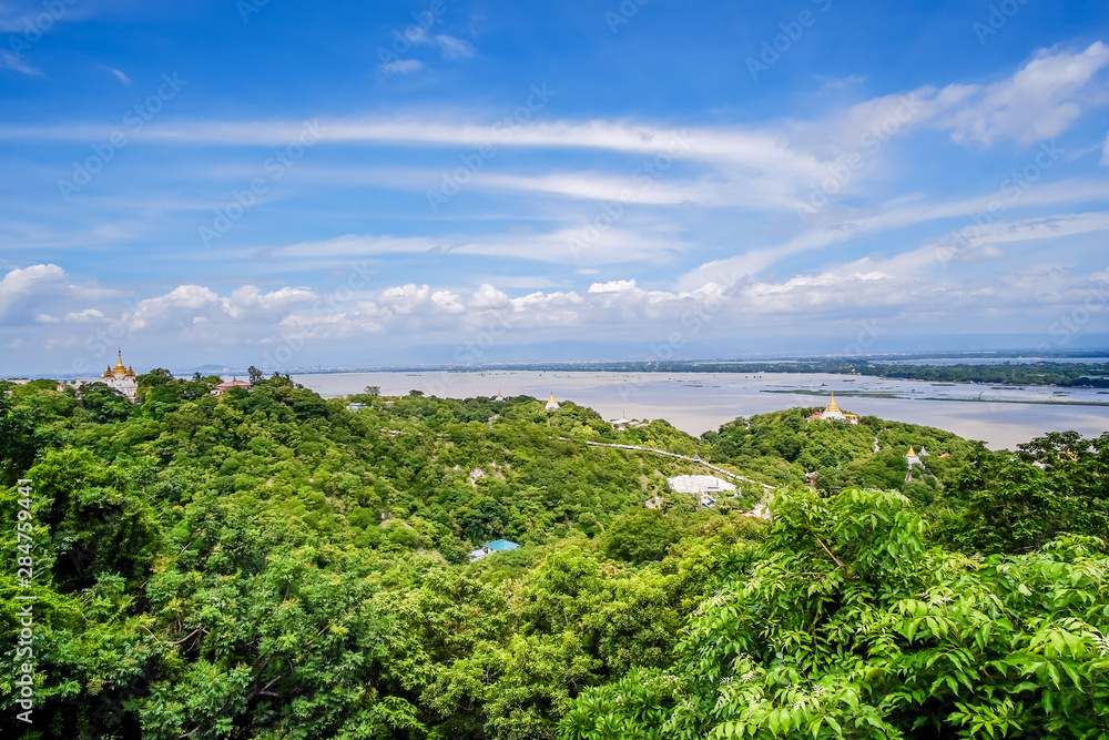 Naklejka premium aerial view of Mandalay city with temples, gold pagoda, Irrawaddy river and bridges from sagaing hill. landmark and popular for tourists attractions in Myanmar