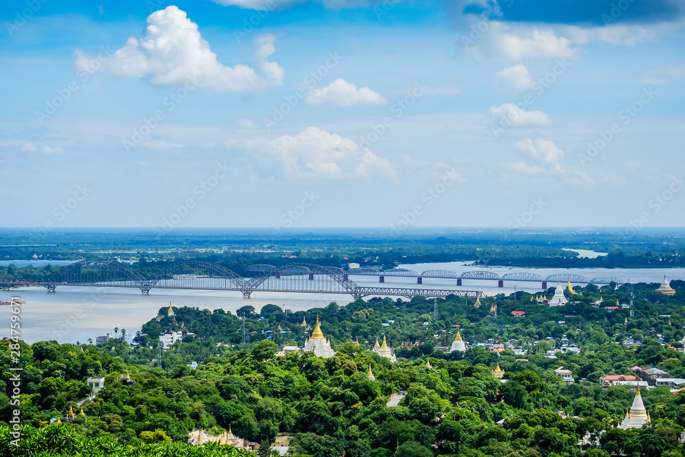 Fototapeta premium Irrawaddy Bridge or Ayeyarwady, Yadanabon Bridges with Mandalay city, temples, pagoda, Irrawaddy river. View from sagaing hill. landmark and popular for tourists attractions in Myanmar