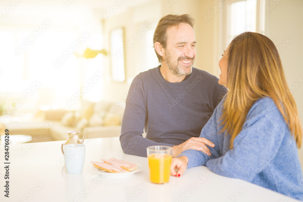 Beautiful romantic middle age couple having healthy breaskfast in the morning at home Beautiful romantic middle age couple having healthy breaskfast in the morning at home