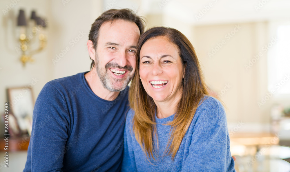 Romantic middle age couple sitting together at home Romantic middle age couple sitting together at home