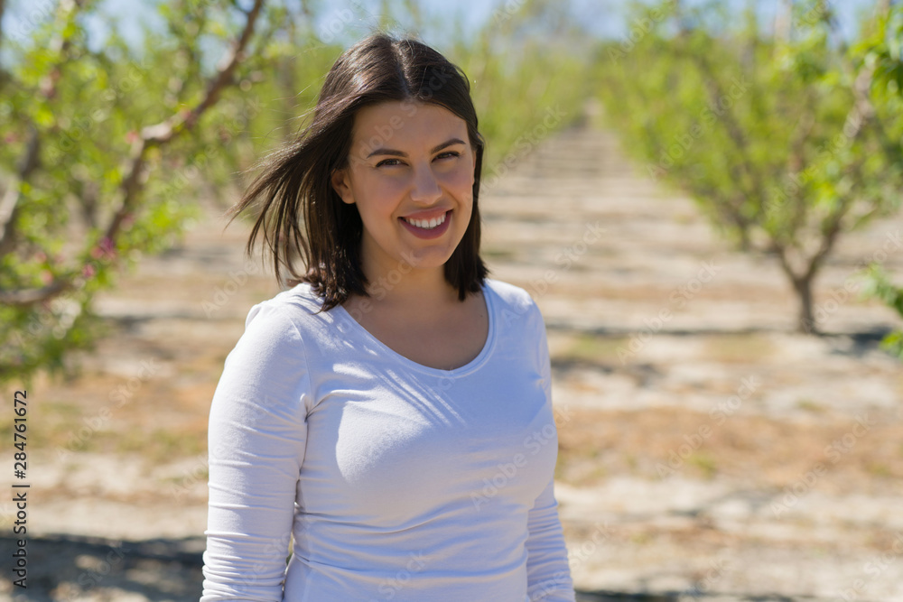 Beautiful young woman smiling cheerful at green trees garden on a sunny day of spring Beautiful young woman smiling cheerful at green trees garden on a sunny day of spring