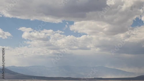 Dramatic clouds timelapse over Badwater basin desert mountain landscape in Death Valley National Park