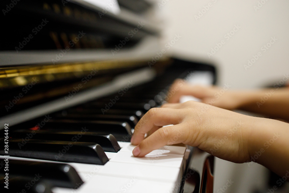 Fototapeta premium Two Small Childent's Hands Playing The Piano