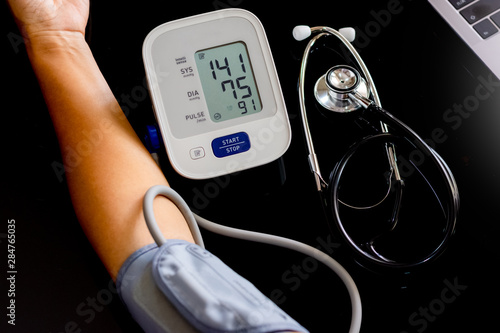 Hypertension, Woman measuring blood pressure.