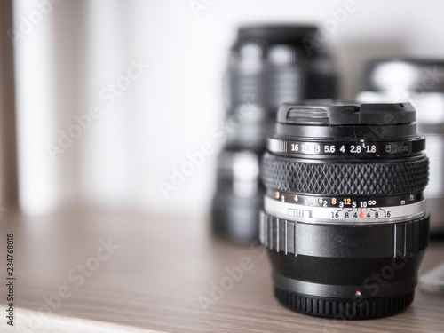 Selective focus of old camera lens on wood self.