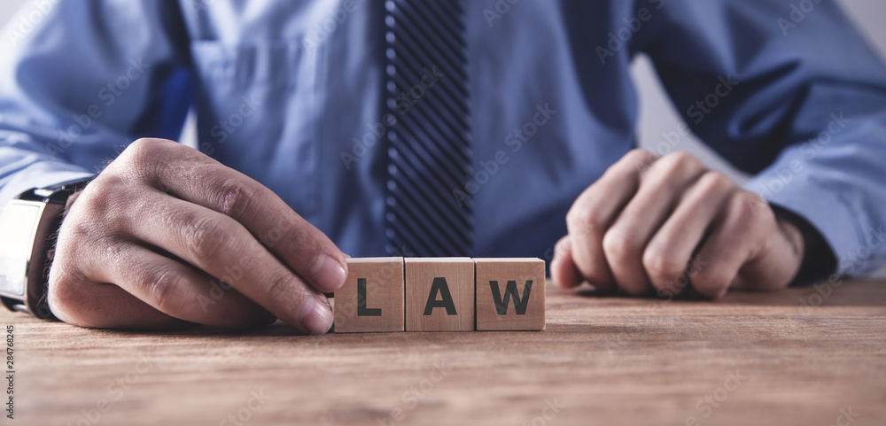 Hand holding wooden cube. Law concept Hand holding wooden cube. Law concept