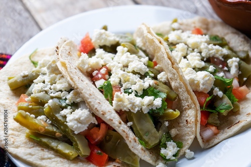 Mexican nopal cactus  tacos with cheese on wooden background photo