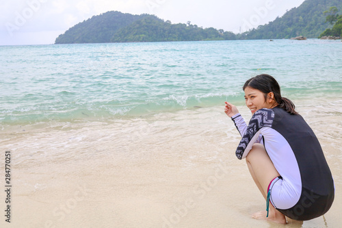 Happy girl on Swimming Suit in front of boat at Surin Islands, Phang Nga Province, Thailand