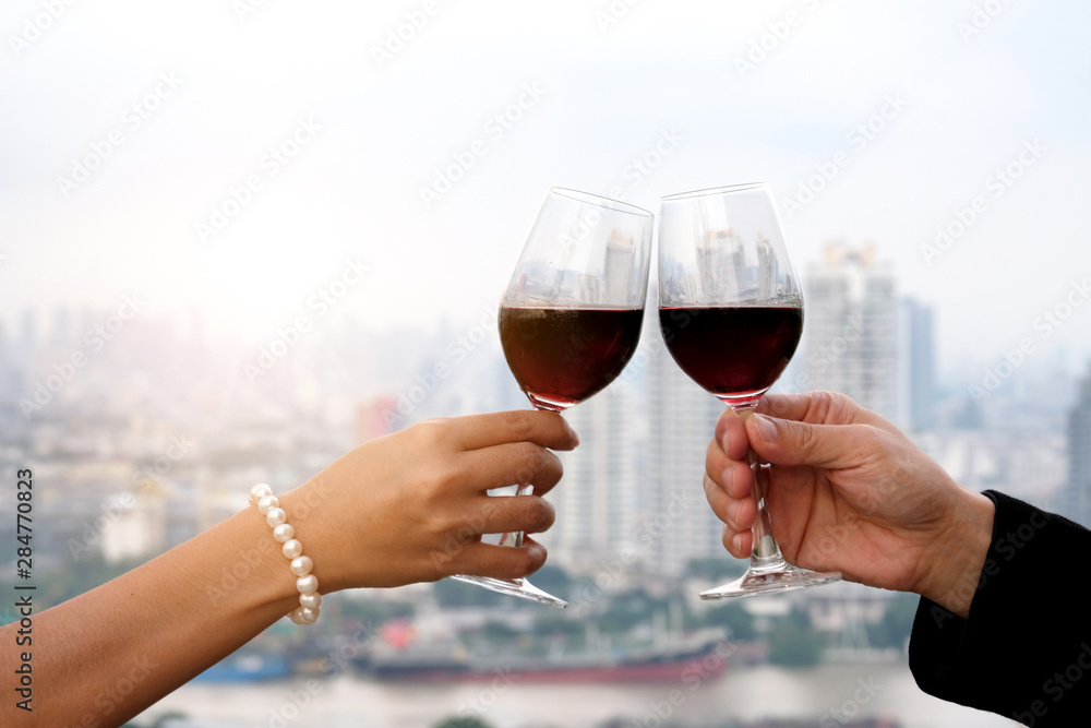 Hand of group friends celebrate successfully with red wine in the party. Young toasting in party and drinking after work hard for relax and be enjoy. Celebration Concept , Cheers!