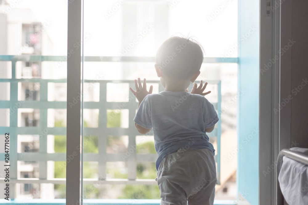 Asian young boy opening the window