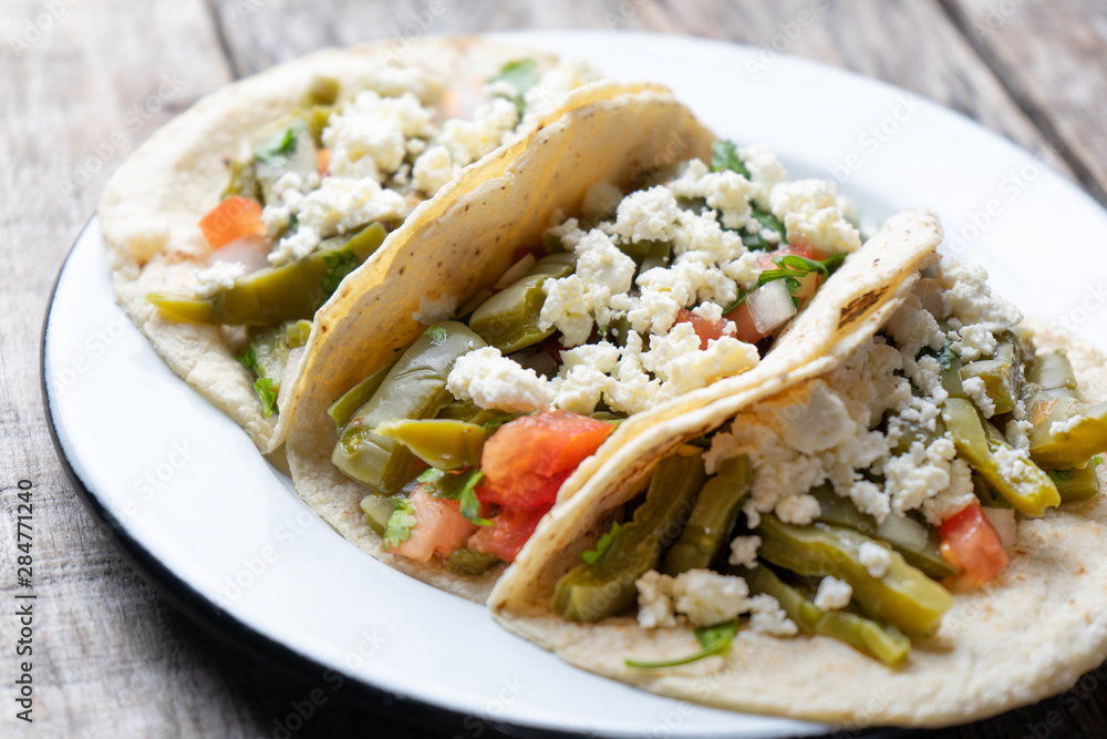 Mexican nopal cactus tacos with cheese on wooden background Mexican nopal cactus tacos with cheese on wooden background