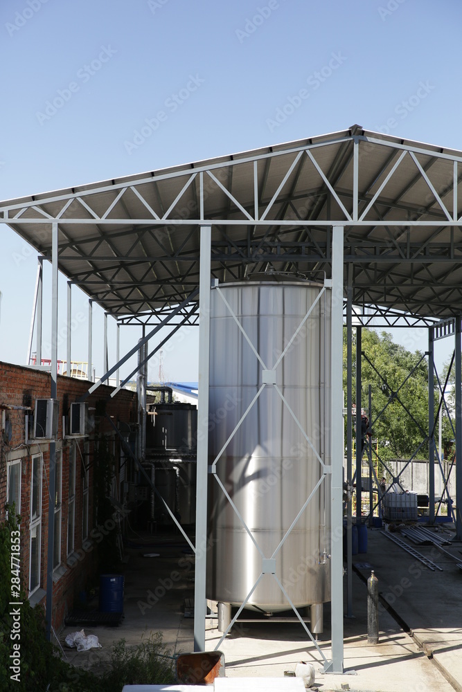 Obraz premium shiny tanks or barrels at a beer and wine factory. Industry Brewing and winemaking. Equipment for the winery and brewing