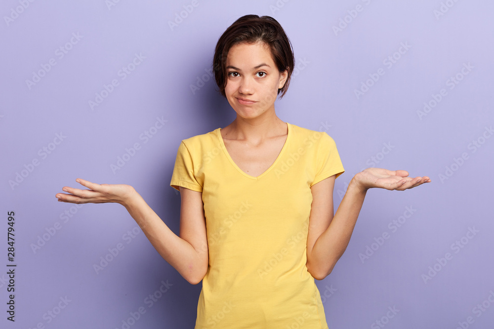 frustrated confused girl with raised arms looking at the camera, isolated blue background, studio shot.disbelief, girl hesitating to act. frustrated confused girl with raised arms looking at the camera, isolated blue background, studio shot.disbelief, girl hesitating to act.