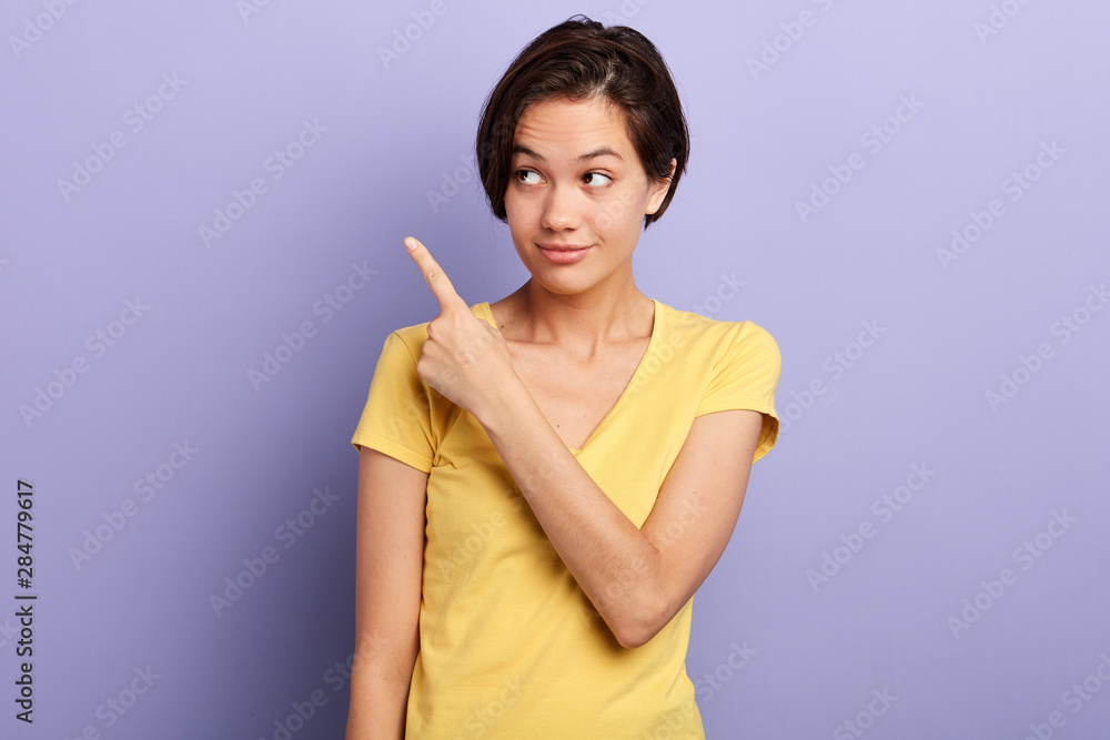 Smiling happy woman pointing finger on copy space. isolated portrait.copy space. advertisement, sale, discount, direction Smiling happy woman pointing finger on copy space. isolated portrait.copy space. advertisement, sale, discount, direction