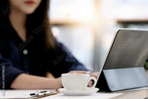 young woman enjoy working at office wiht hot cup of coffee.