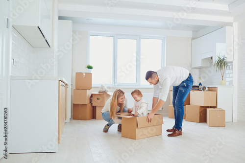 Happy family unpacking boxes at new home © Studio Romantic