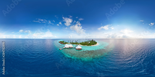 Fototapeta Naklejka Na Ścianę i Meble -  Aerial spherical panorama of tropical paradise beach  on tiny Maldives island. Turquoise ocean and white sand. Small bungalows between coconut palm trees