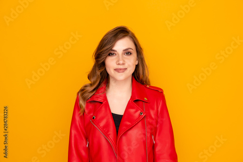 Portrait of pretty young woman in the red clothes isolated over the yellow background.