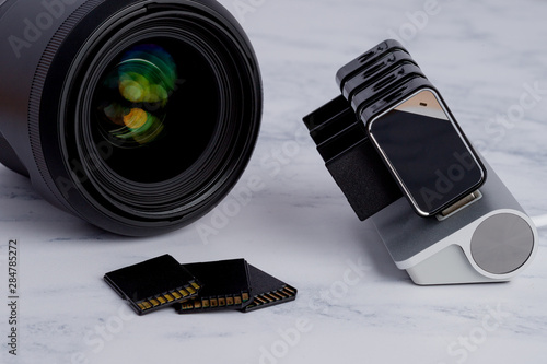 Professional Photography Equipment on Table. SD Cards transferring Photos from Camera to Computer.