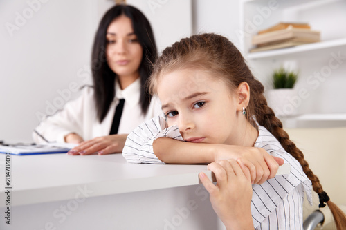 Female psychologist working with girl in the white cabinet