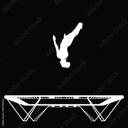 A woman is doing a backflip on a trampoline in the gym