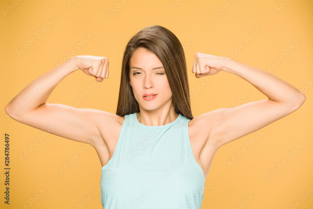 Young woman showing her hands on yellow background Young woman showing her hands on yellow background