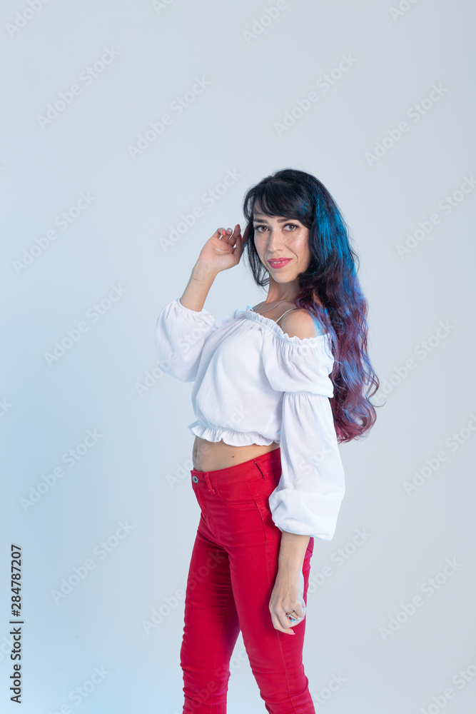 Latin dance, contemporary dance, bachata solo and cha-cha-cha concept - portrait of a young woman salsa dancer in a dance pose on blue background Latin dance, contemporary dance, bachata solo and cha-cha-cha concept - portrait of a young woman salsa dancer in a dance pose on blue background