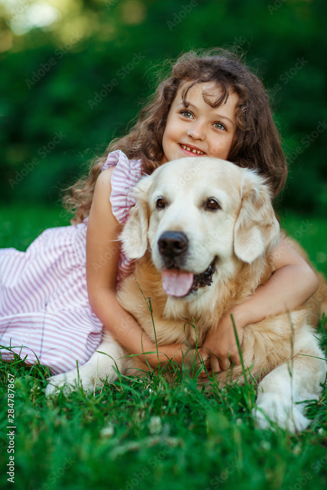 Little girl with a golden retriever, outdoor summer Little girl with a golden retriever, outdoor summer