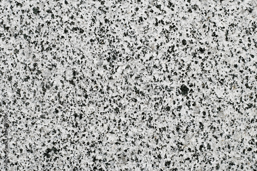 Black and white granite surface, stone motley wall. Marble quartz texture. Abstract stained grunge background, pattern. Gray mineral pocked slab.