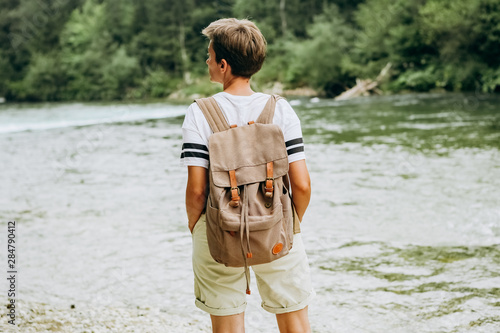 girl tourist backside backpack bank mountain river