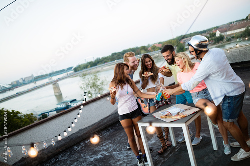 Carefree group of friends enjoying party on rooftop