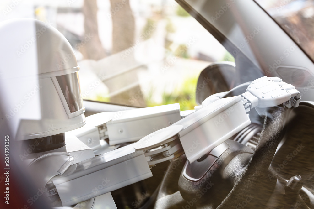 autonomous white robot is driving a car autonomous white robot is driving a car