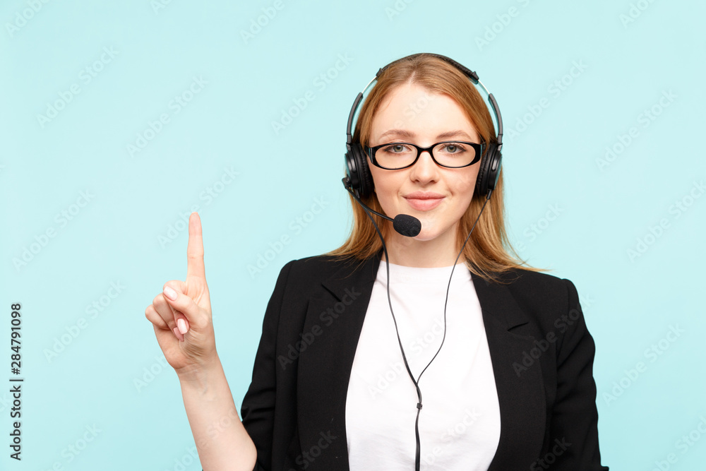 Happy female call center operator in the blue studio pointing something Happy female call center operator in the blue studio pointing something