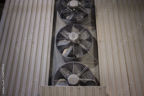 Industrial fan. Three gray industrial fan on the gray wall at the plant