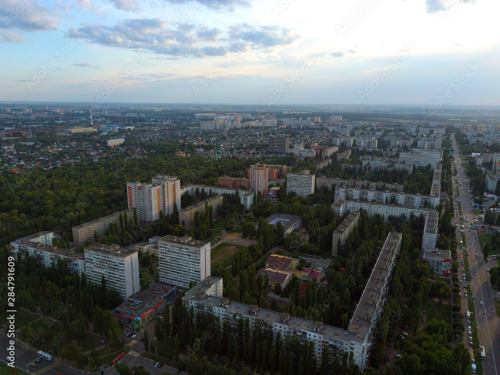 Aerial view to the modern residential buildings. Exterior of high-rise residential building the facades. Residential building surrounded by trees. Skyscrapers in the forest environment