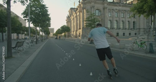 Wallpaper Mural Handsome Europian man skating and doing cool tricks on roller skates in white blue t-shirt at city downtown location.Artistic improvisation of professional skating and spinning tricks.Camera following Torontodigital.ca