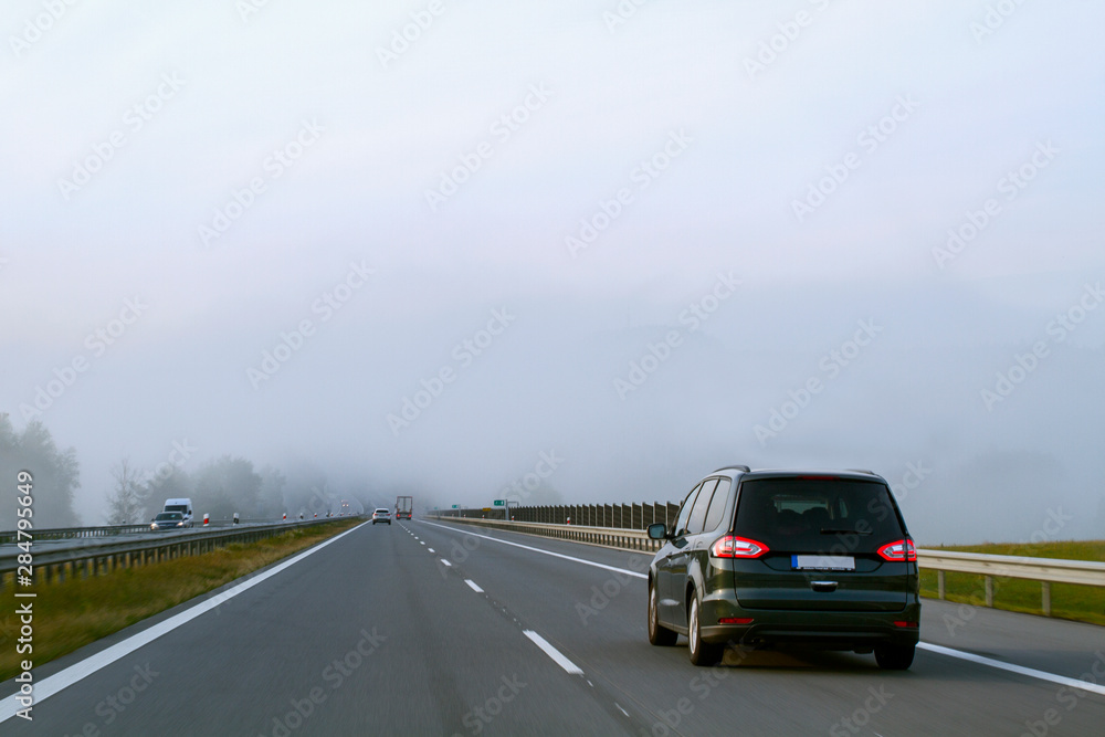 Car driving on  highway in heavy fog. Traffic safety  .   Fall travel, bad weather.