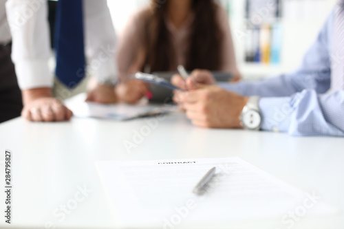 Focus on important business contract or project. Smart partners sitting in modern office and discussing significant strategy. Biz meeting concept. Blurred background