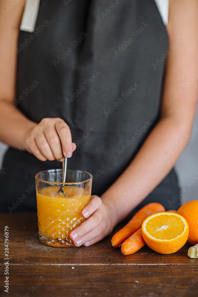 Fitness young woman drinking orange smoothie in Kitchen Fitness young woman drinking orange smoothie in Kitchen