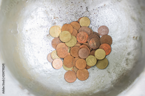 The coin in monk's bowl or almsbowl, Selective focused coins in old monk's alms-bowl, Coin in statue monk's alms bowl, A lot of monk's bowl or alms bowl in the Buddhism temple Chiangmai, Thailand photo