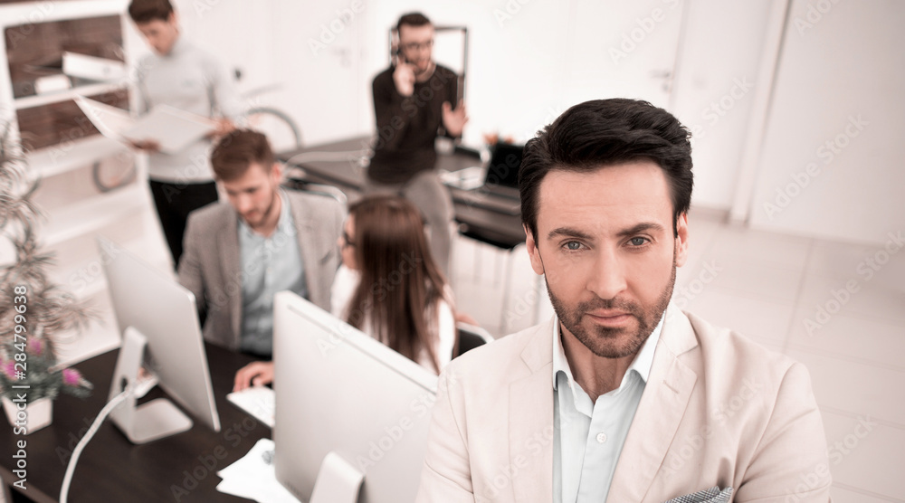 confident businessman in the background of his office confident businessman in the background of his office