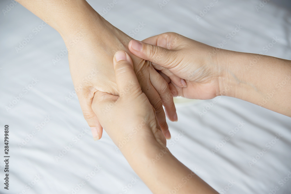 Hand spa massage over clean white bed background - people relax with hand massage service Hand spa massage over clean white bed background - people relax with hand massage service