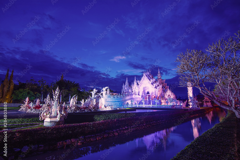 white temple or wat rung kun, famous temple in chiang rai with twilight sky and light up.