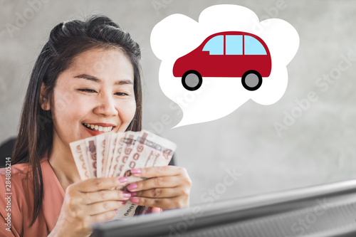happy Asian business woman hand holding banknotes ,planing to buy new car