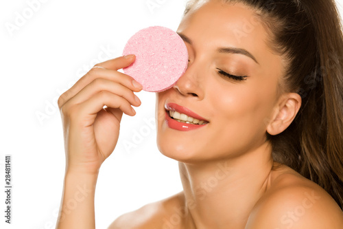 young beautiful woman posing with a sponge pad on the white background