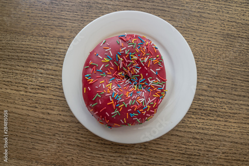 Pink donut on white plate