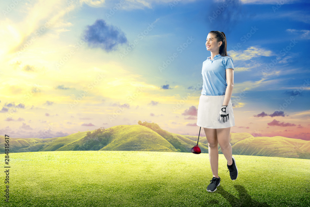 Asian woman standing with a wood golf club Asian woman standing with a wood golf club