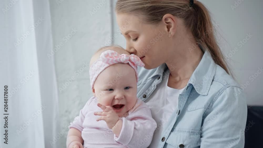 happy mother smelling and kissing infant daughter happy mother smelling and kissing infant daughter
