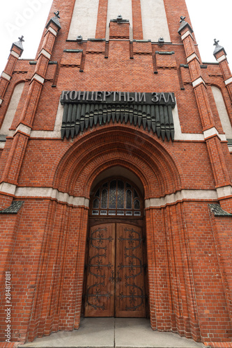 Catholic church of Holy Family in Russia, Kaliningrad city. Neogothic red brick building style. Inscription Concert Hall . photo