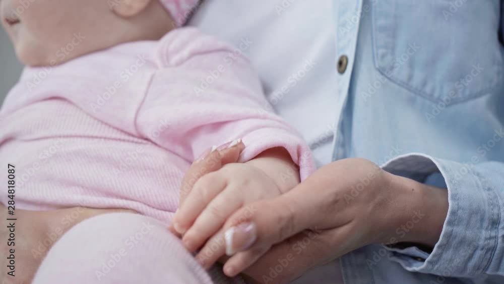 rack focus of mother kissing hand of infant daughter rack focus of mother kissing hand of infant daughter